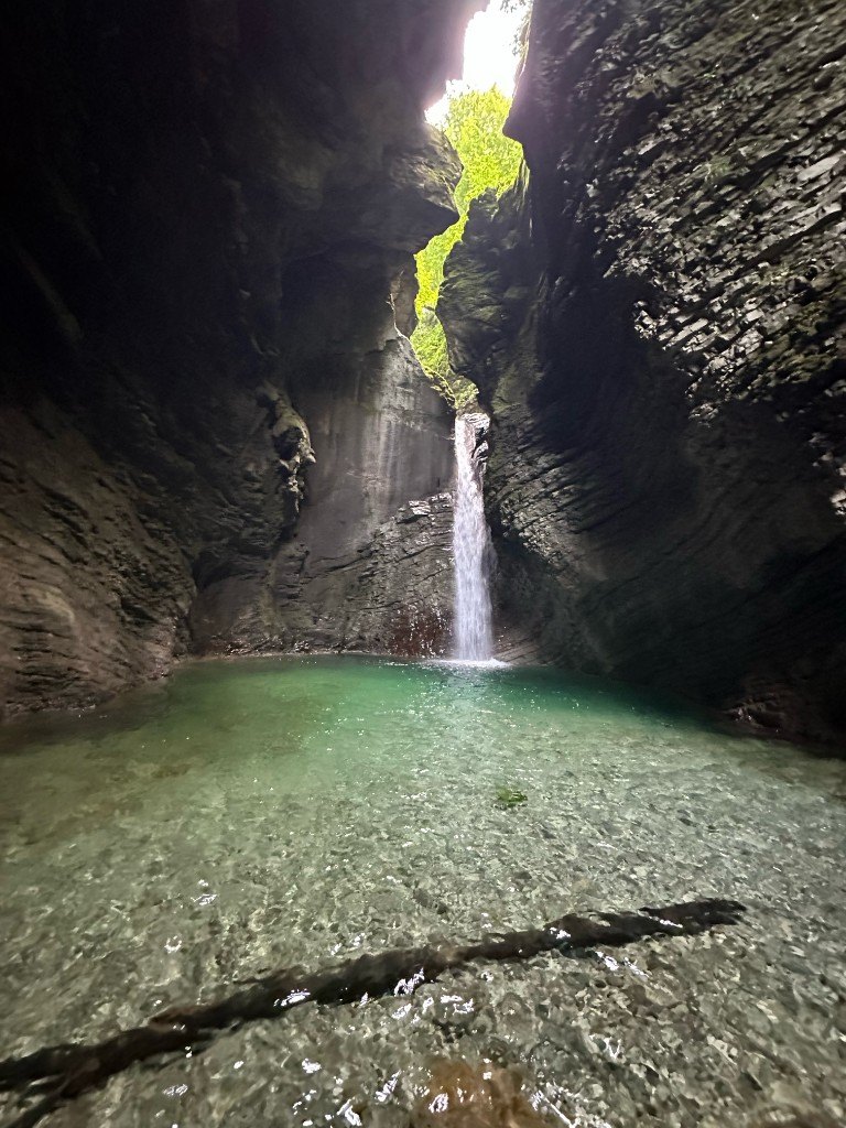 Kozjak Waterfall dropping into a clear pool inside a rock amphitheater near Kobarid, Slovenia