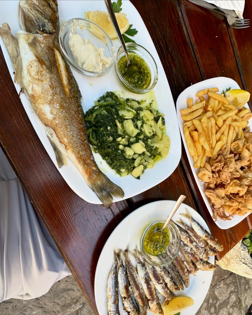 Grilled fish, sardines, calamari and fries at a seafood lunch in Piran, Slovenia