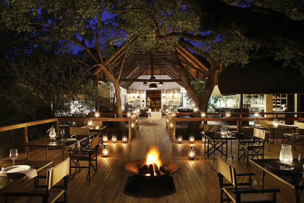 Evening dining deck at Londolozi Tree Camp under lantern light