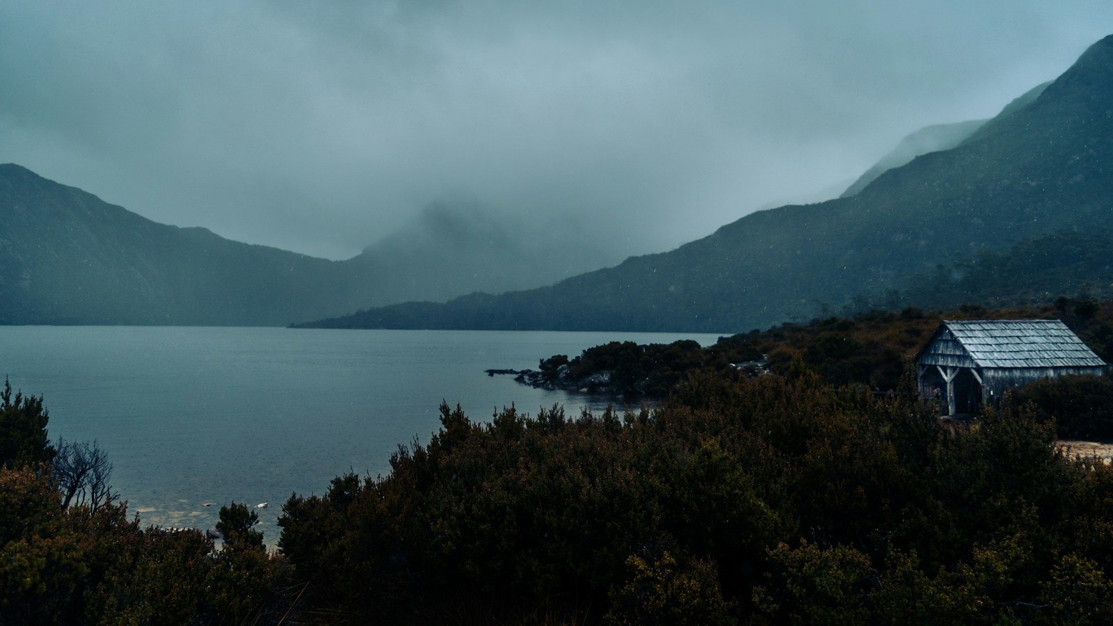 Dove Lake and the rugged Cradle Mountain landscape beneath misty skies