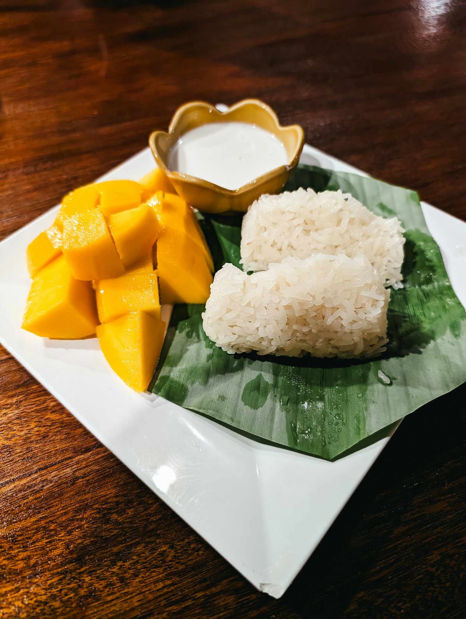 Plate of mango sticky rice with coconut sauce