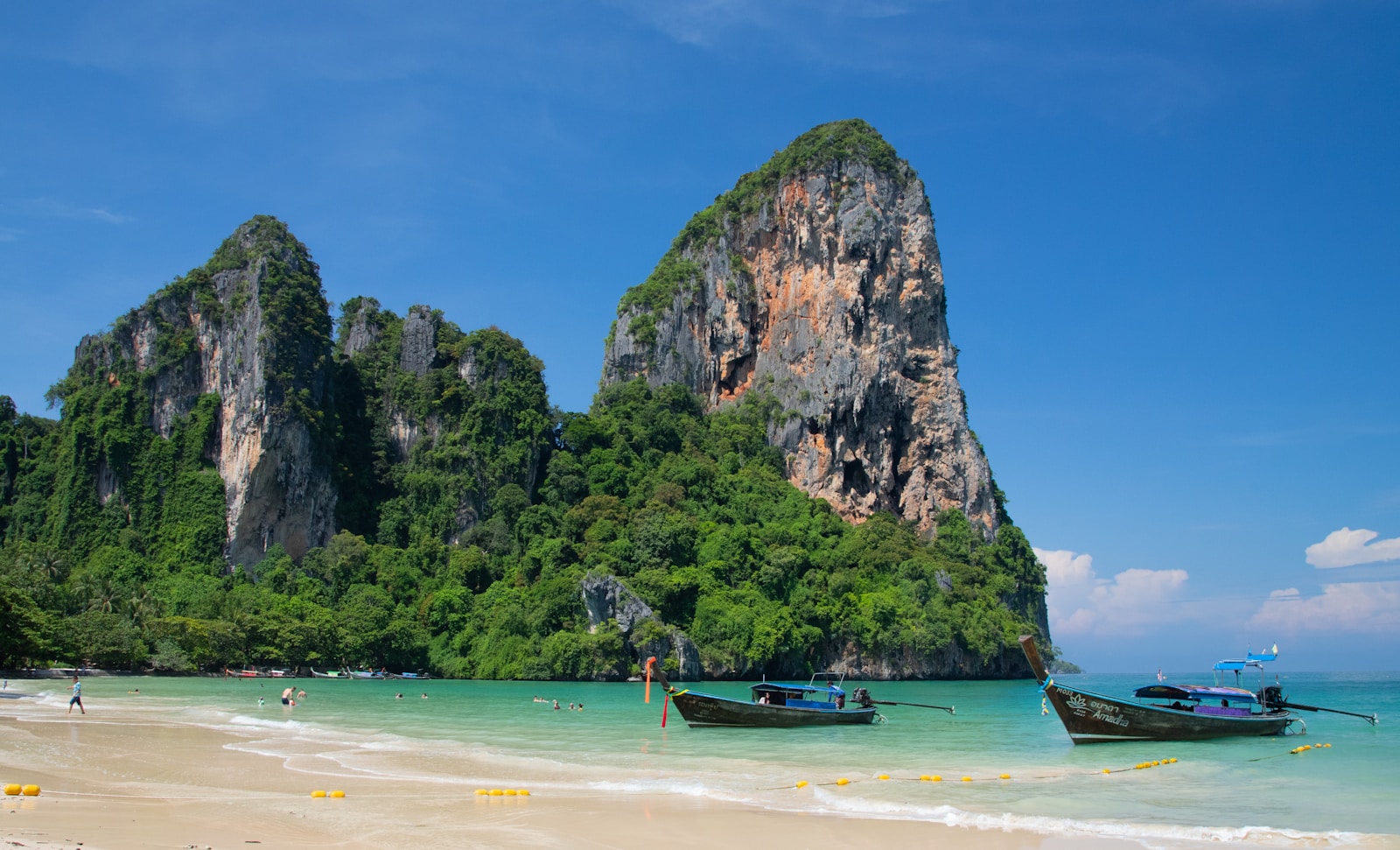 Railay Beach with long-tail boats and limestone cliffs in Thailand