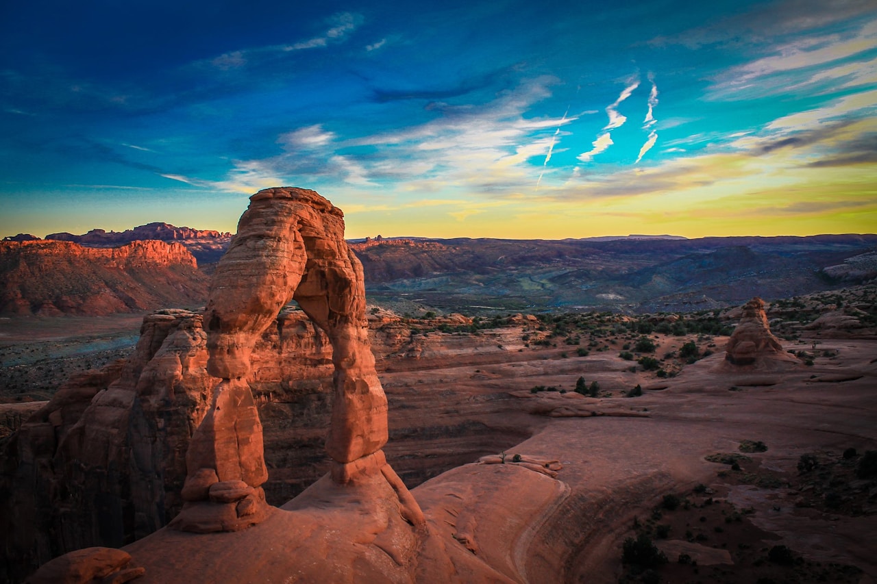 Delicate Arch at sunset in Arches National Park, Utah, with sweeping desert canyon views