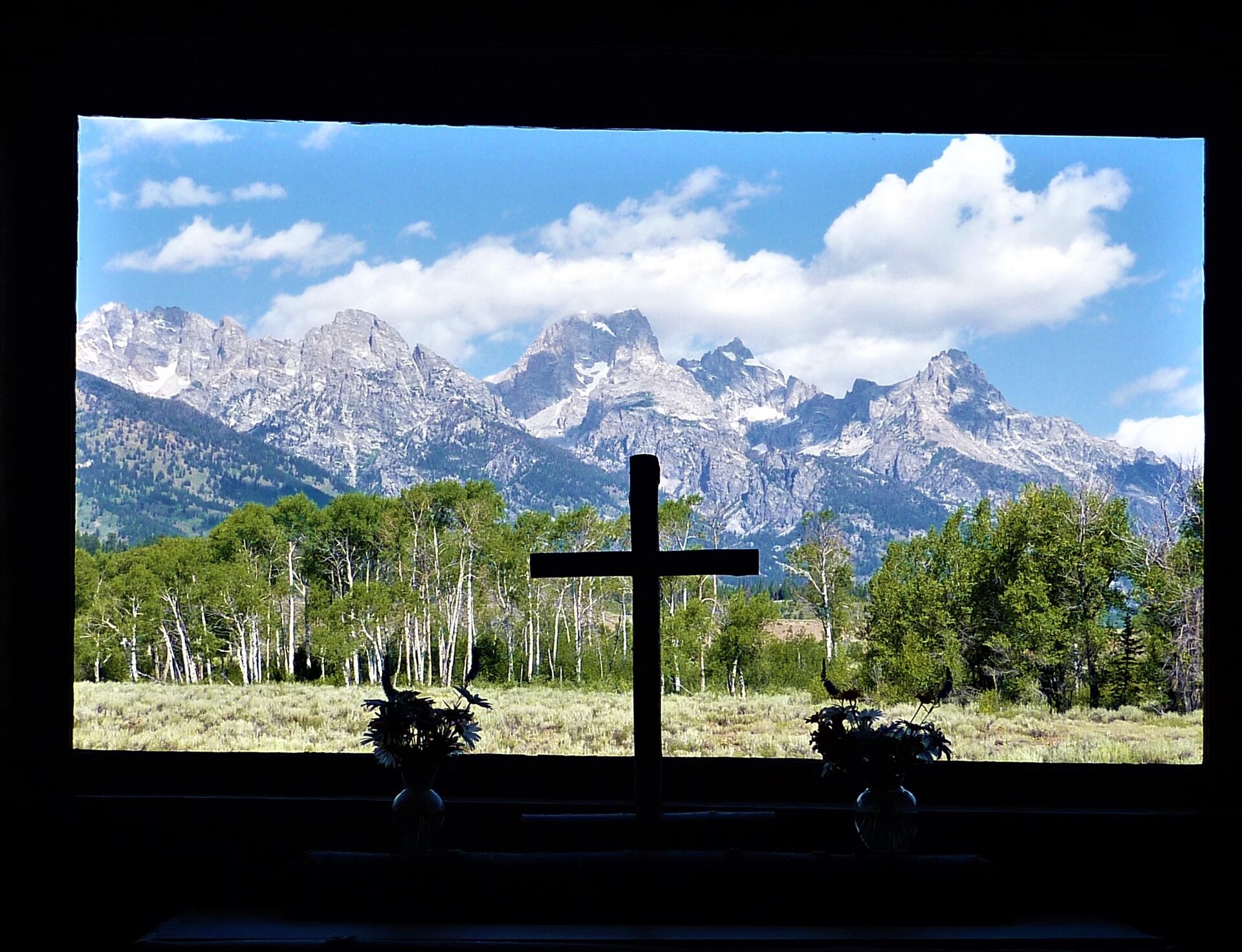 View through the Chapel of the Transfiguration altar window framing the Teton Range