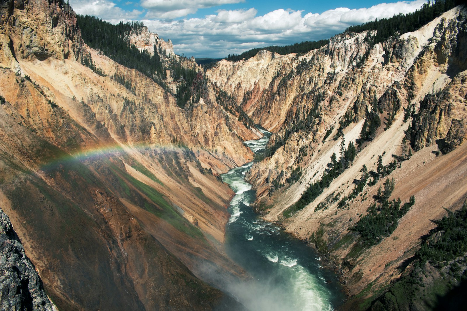Grand Canyon of the Yellowstone with golden, orange, and pink volcanic rock walls