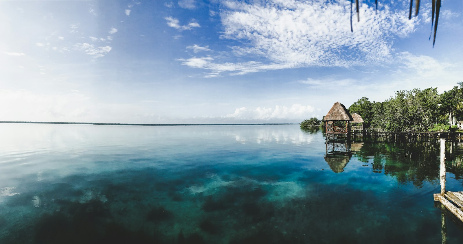 Wooden house on turquoise Bacalar Lagoon under a blue sky in Quintana Roo, Mexico