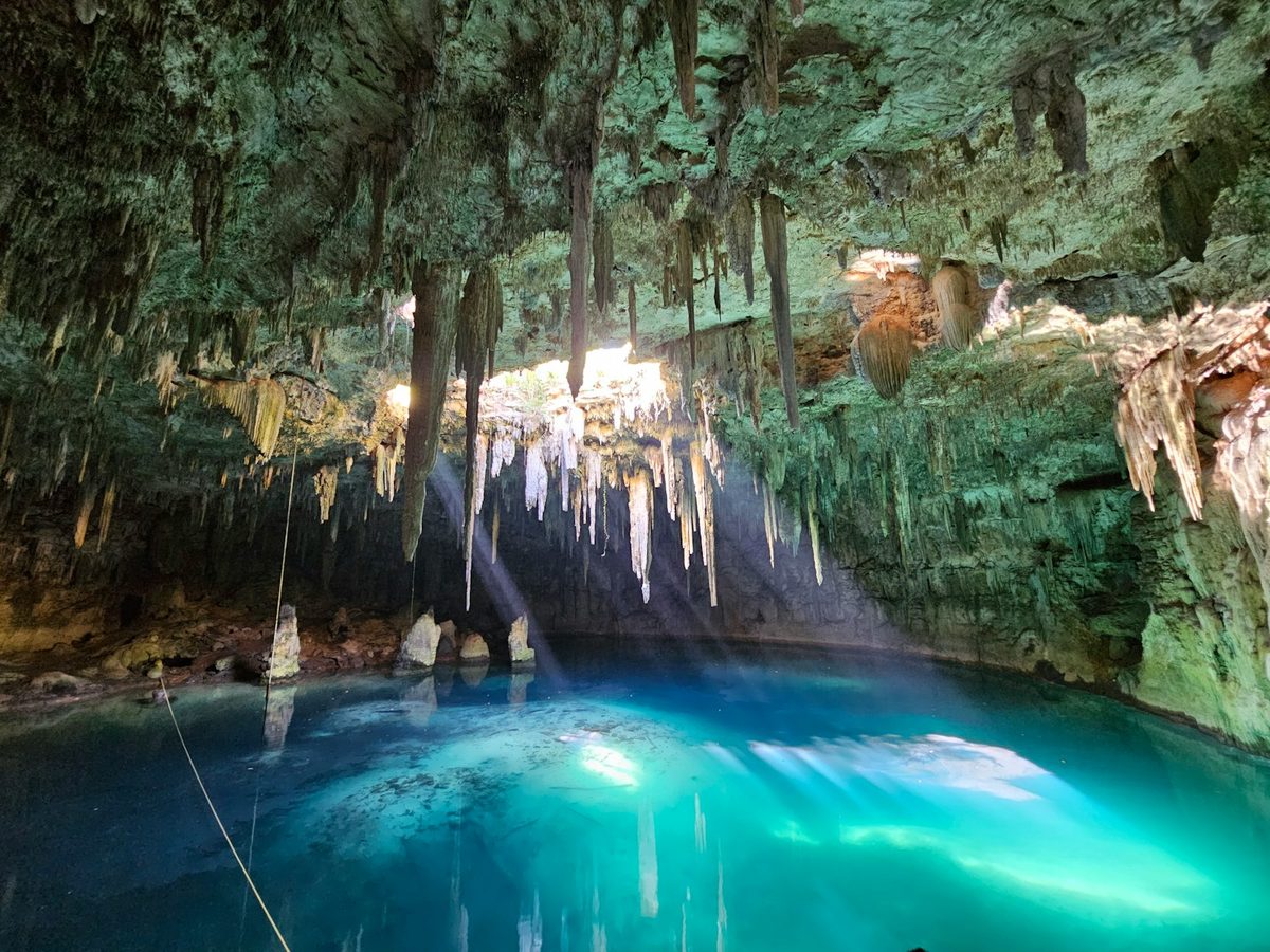 Cenote Xcanahaltun, a blue pool in a cave with hanging stalactites in Temozón, Yucatán, Mexico